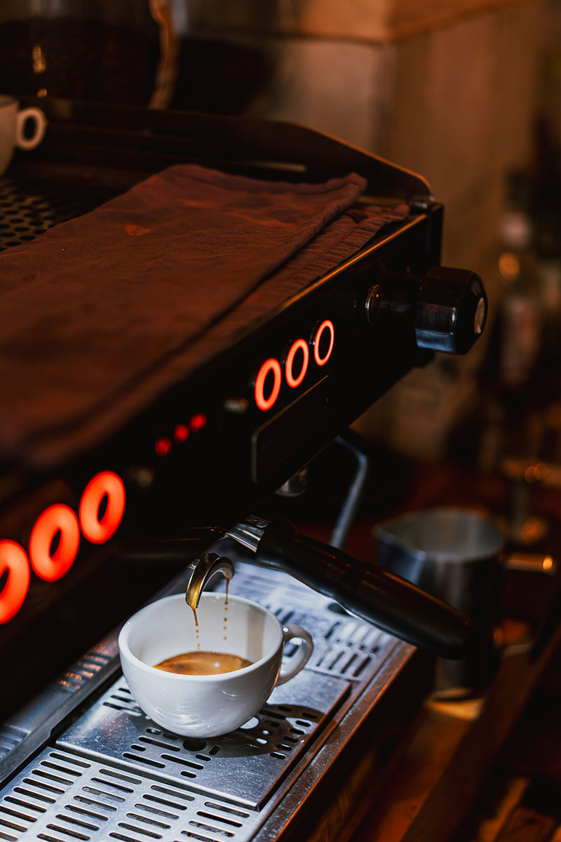 Hochwertige Siebträgermaschiene mit der gerade ein Espresso zubereitet wird.